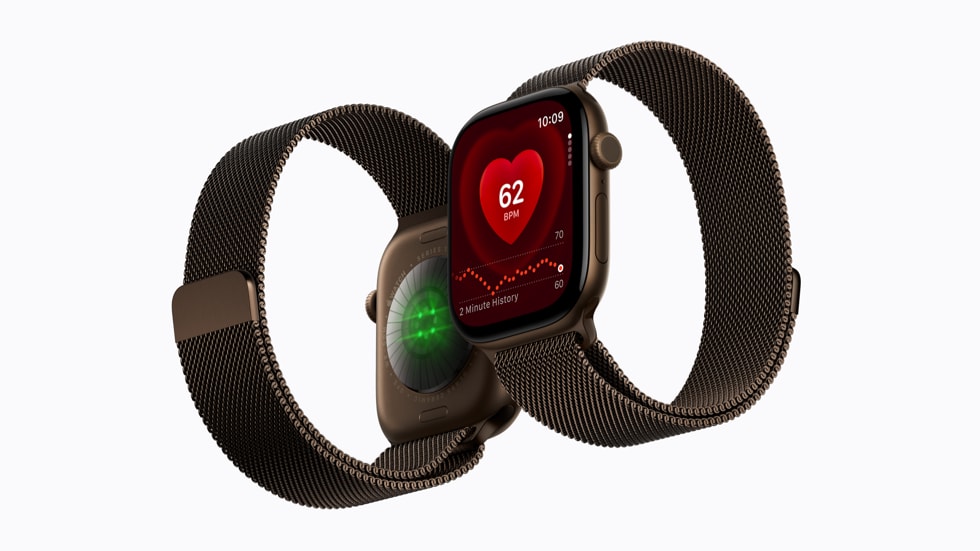 Apple 官方产品图：两只深色金属网状表带的 Watch Series 12，分别展示心率界面和亮起绿光的背部传感器。